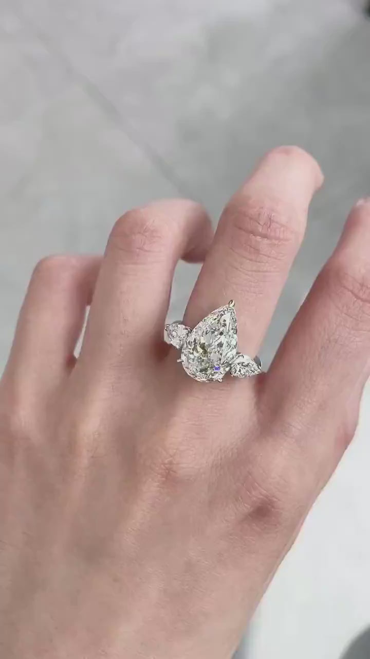 DEF color VVS/VS pear cut center diamond with matching tapered side stones, available in platinum or 18KT gold for heirloom brilliance.