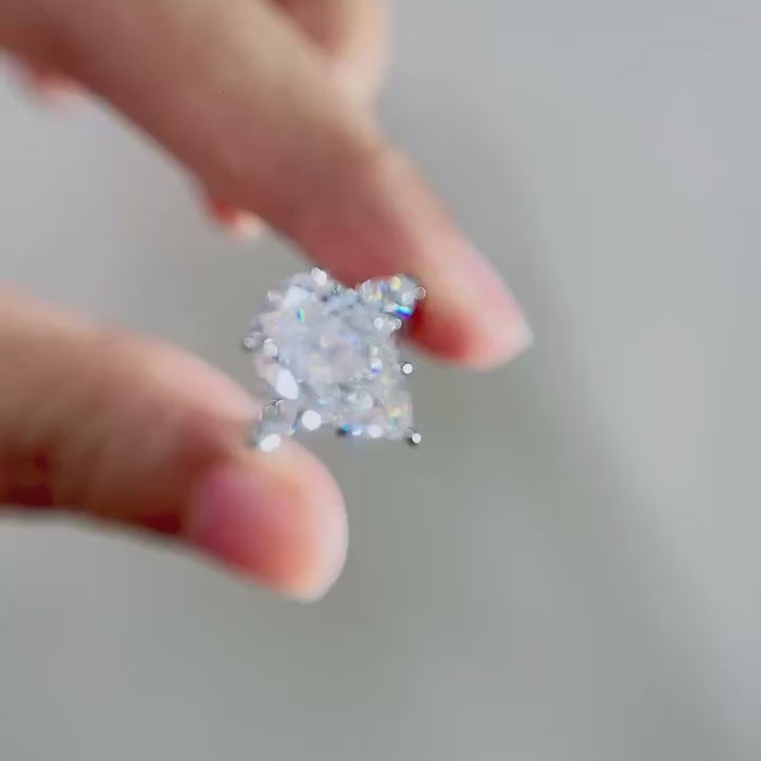 Elegant pear cut lab-grown diamond engagement ring featuring trillion side diamonds, DEF color VVS/VS clarity, customizable center stone weights in solid gold or platinum.