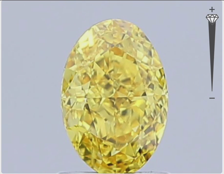 loose fancy vivid yellow oval diamond gemstone with brilliant cut facets against white background