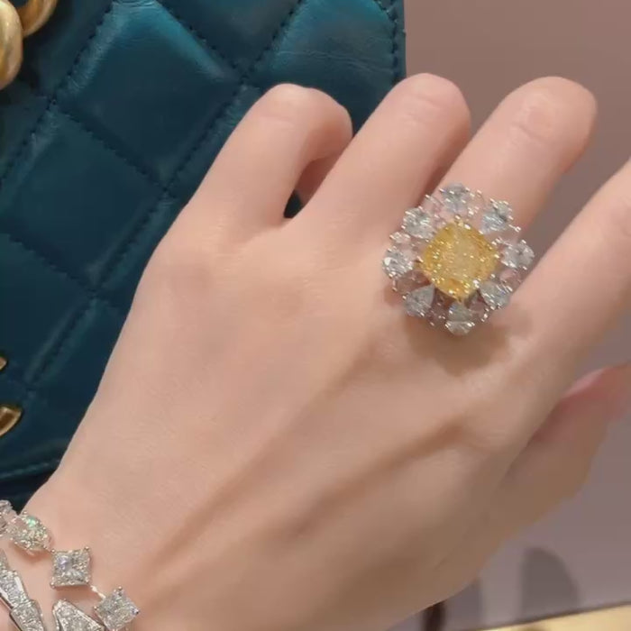 extreme close-up of cushion fancy yellow lab diamond ring with detailed pear halo arrangement highlighting brilliance and hand-set craftsmanship