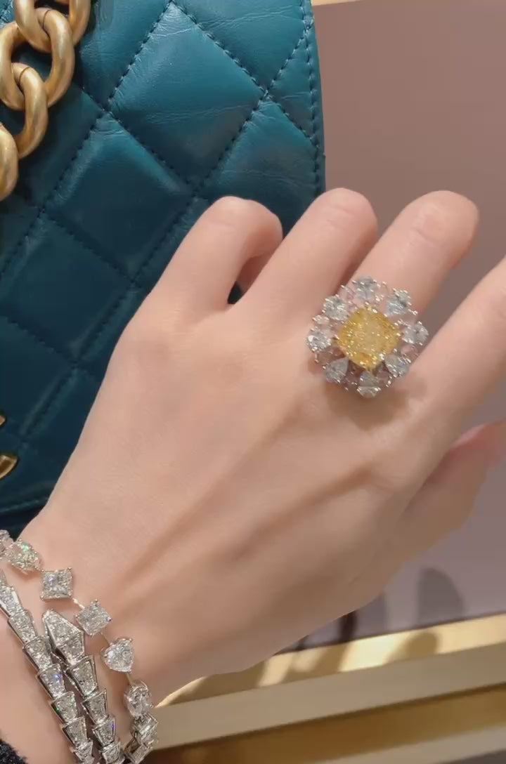 extreme close-up of cushion fancy yellow lab diamond ring with detailed pear halo arrangement highlighting brilliance and hand-set craftsmanship