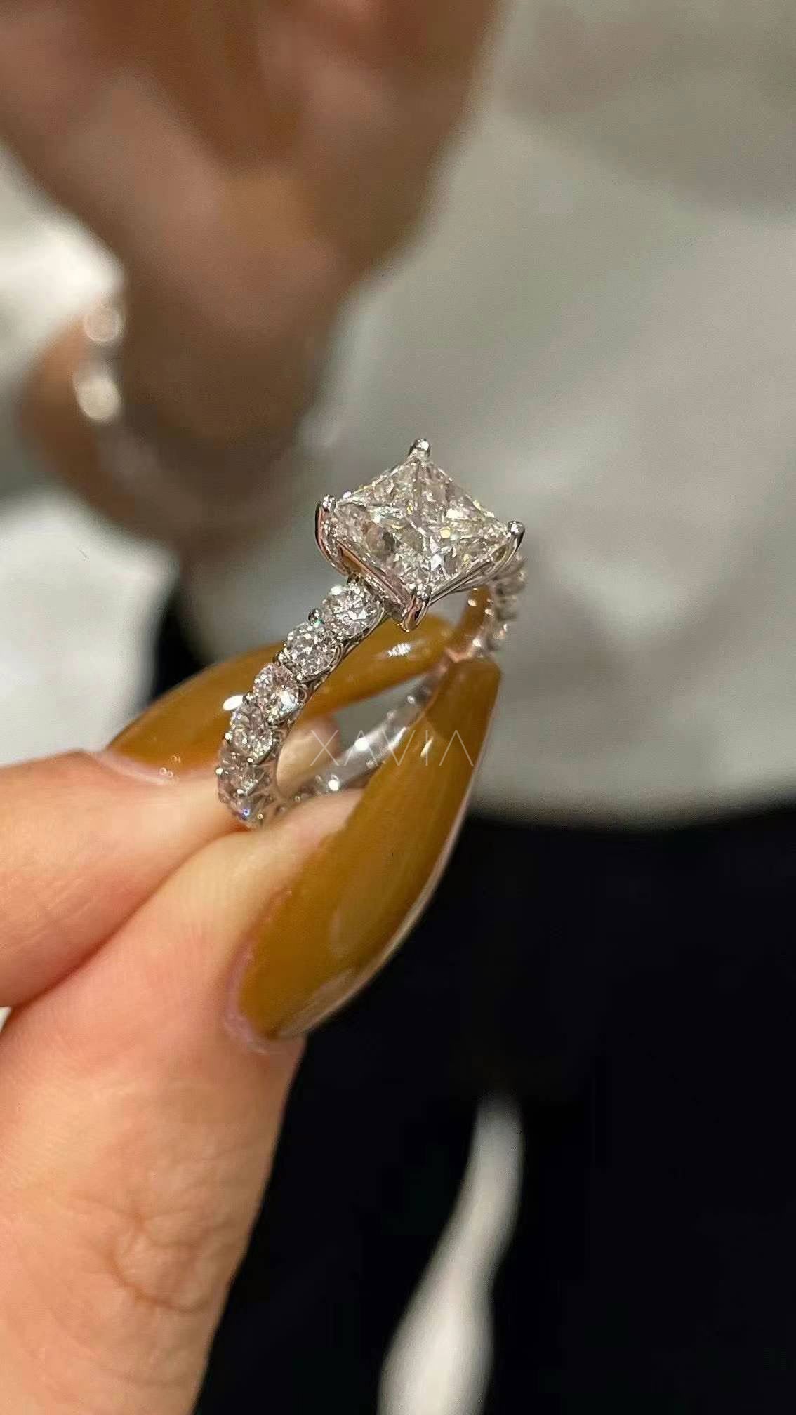 close-up of princess cut lab diamond engagement ring with pavé band worn on model’s hand, showcasing sparkle