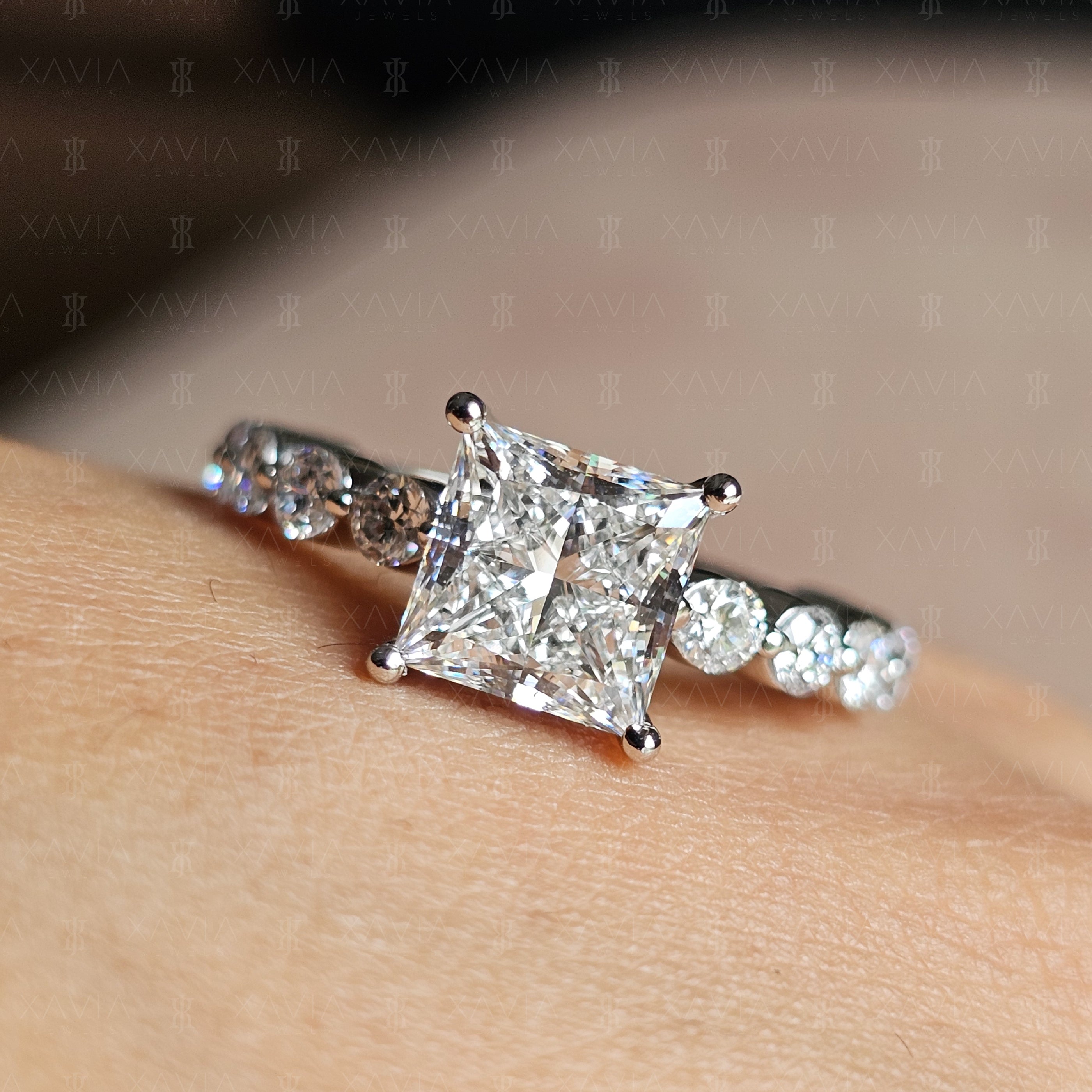 Close-up view of princess cut lab-grown diamond engagement ring with four-prong solitaire setting and round brilliant eternity band in white metal