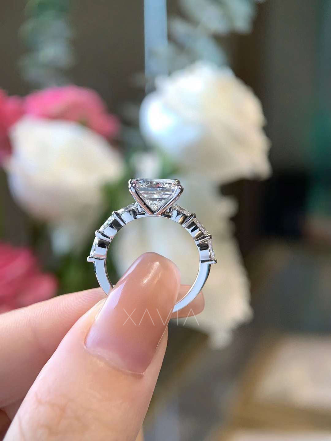 Side profile of a princess cut lab-grown diamond engagement ring showing marquise accent diamonds along the band and elevated four-prong solitaire setting