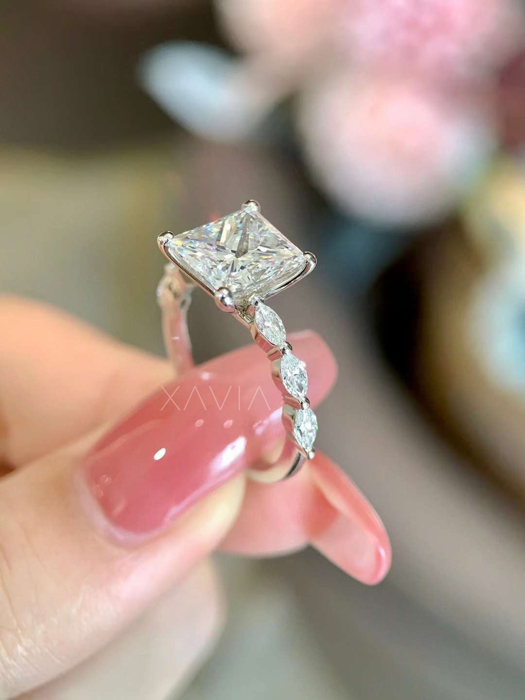 Three-quarter angle view of a princess cut lab-grown diamond ring with marquise accent diamonds along the band highlighting the elevated solitaire setting