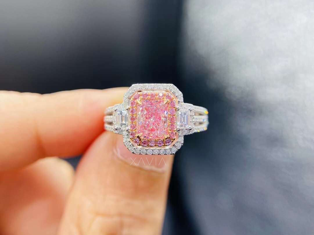 radiant pink cushion lab diamond ring with dual halo and baguette accents in white gold, held in hand