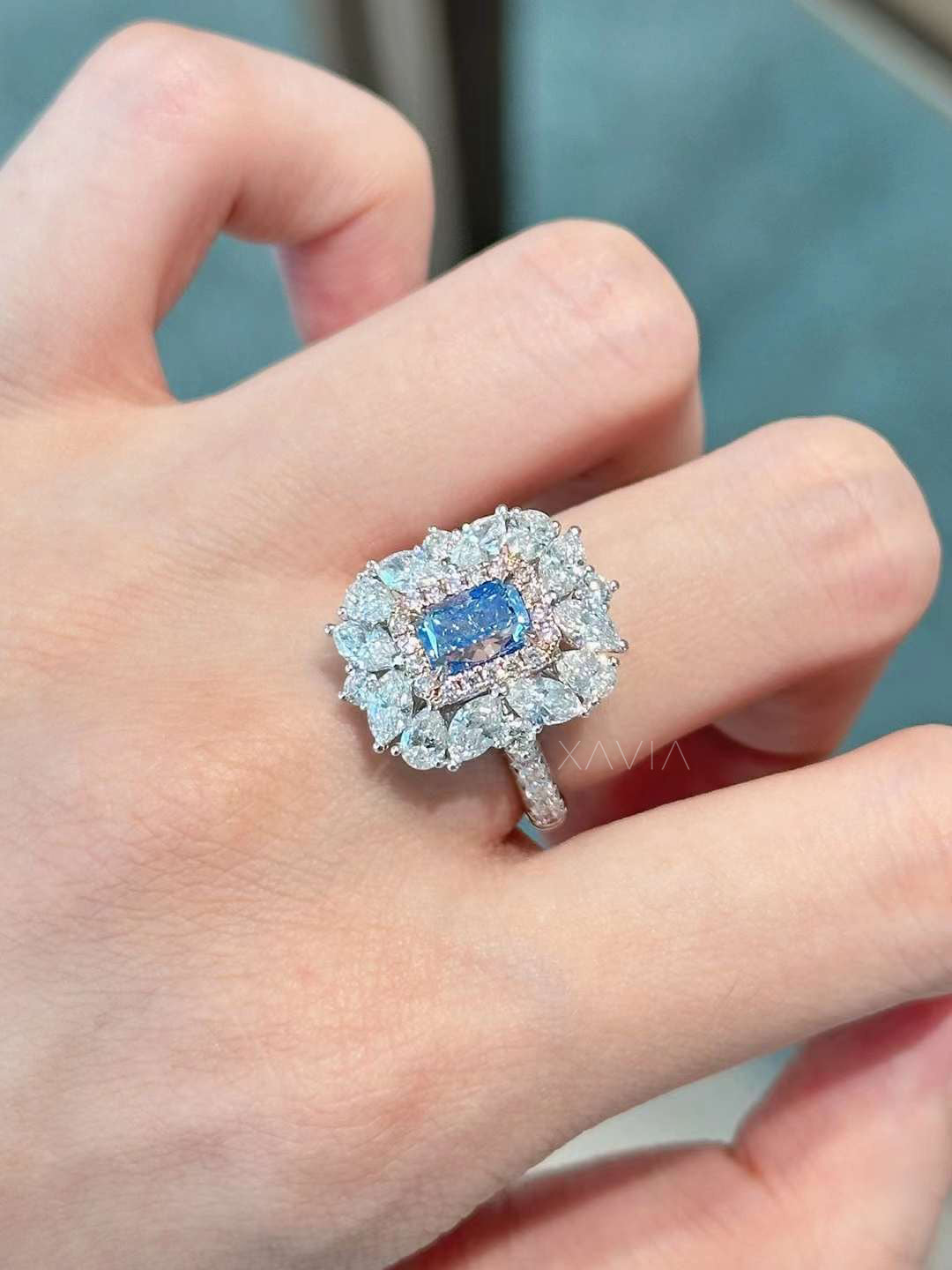 front profile of double halo blue emerald cut lab diamond ring with floral-inspired design and full sparkle setting