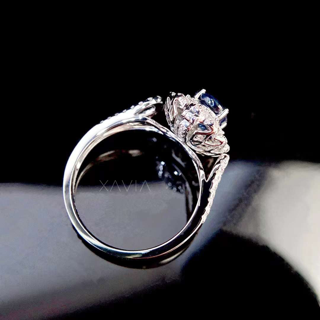 side gallery detail of oval sapphire halo engagement ring highlighting intricate diamond halo structure and polished white metal band