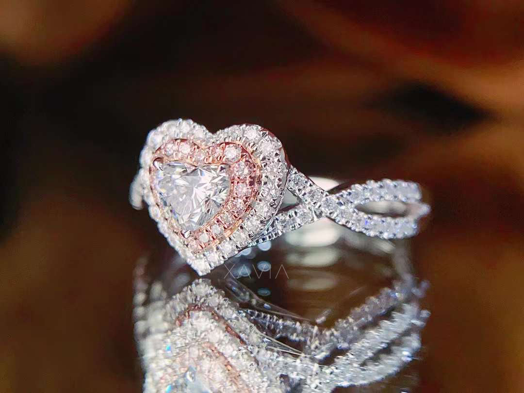 heart cut lab diamond engagement ring with rose gold inner halo and white diamond outer halo on reflective surface