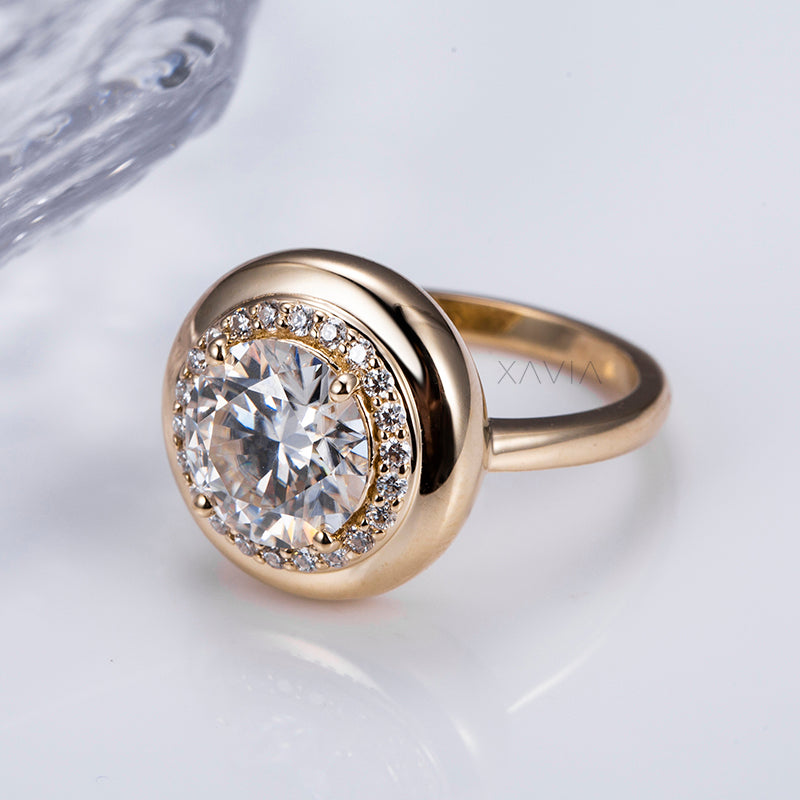 close-up view of round brilliant lab diamond bezel halo ring in domed yellow gold with pavé accents, high-polish finish