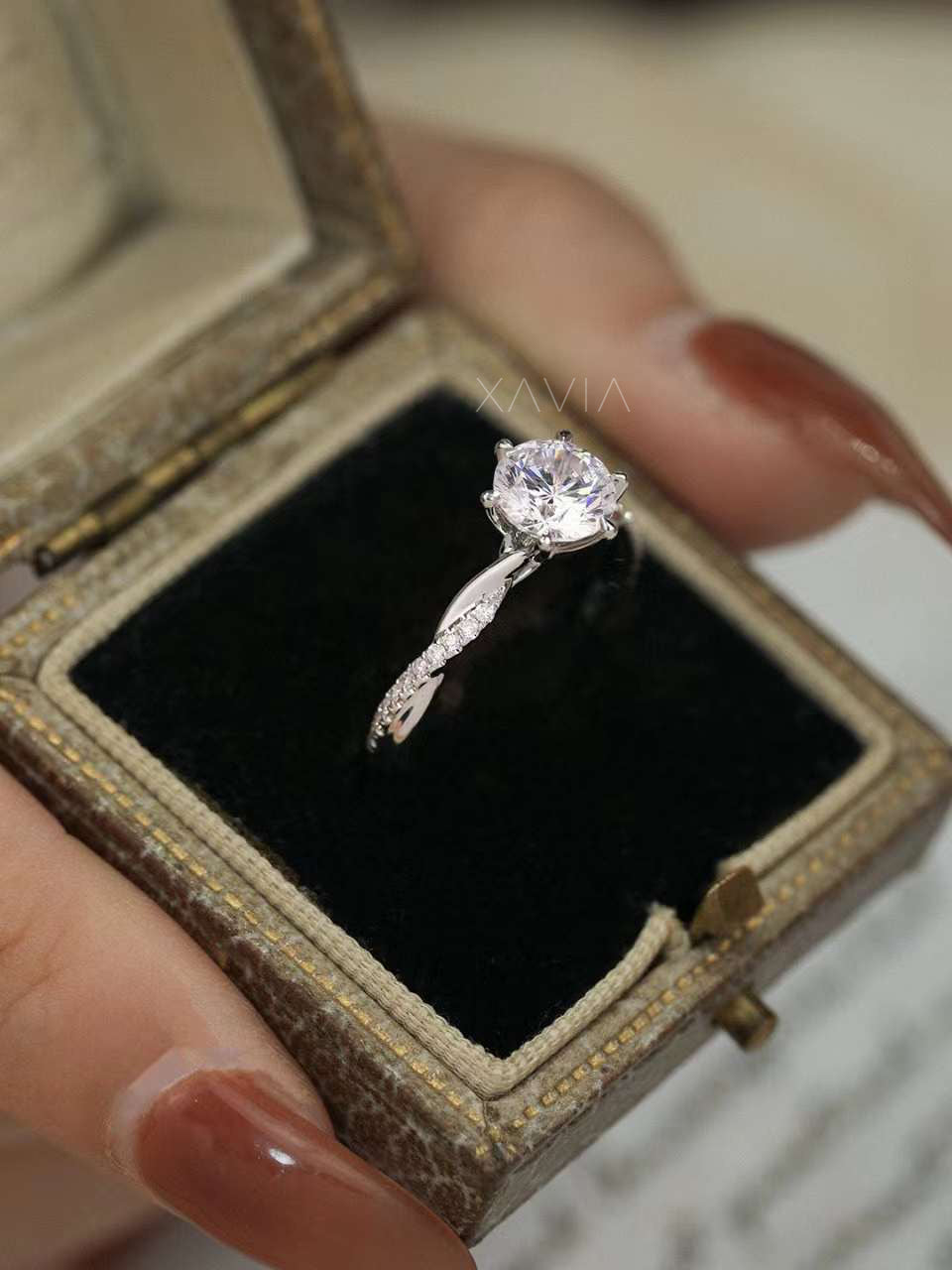 Solitaire engagement ring with round brilliant lab diamond and pavé twisted band displayed in vintage jewelry box