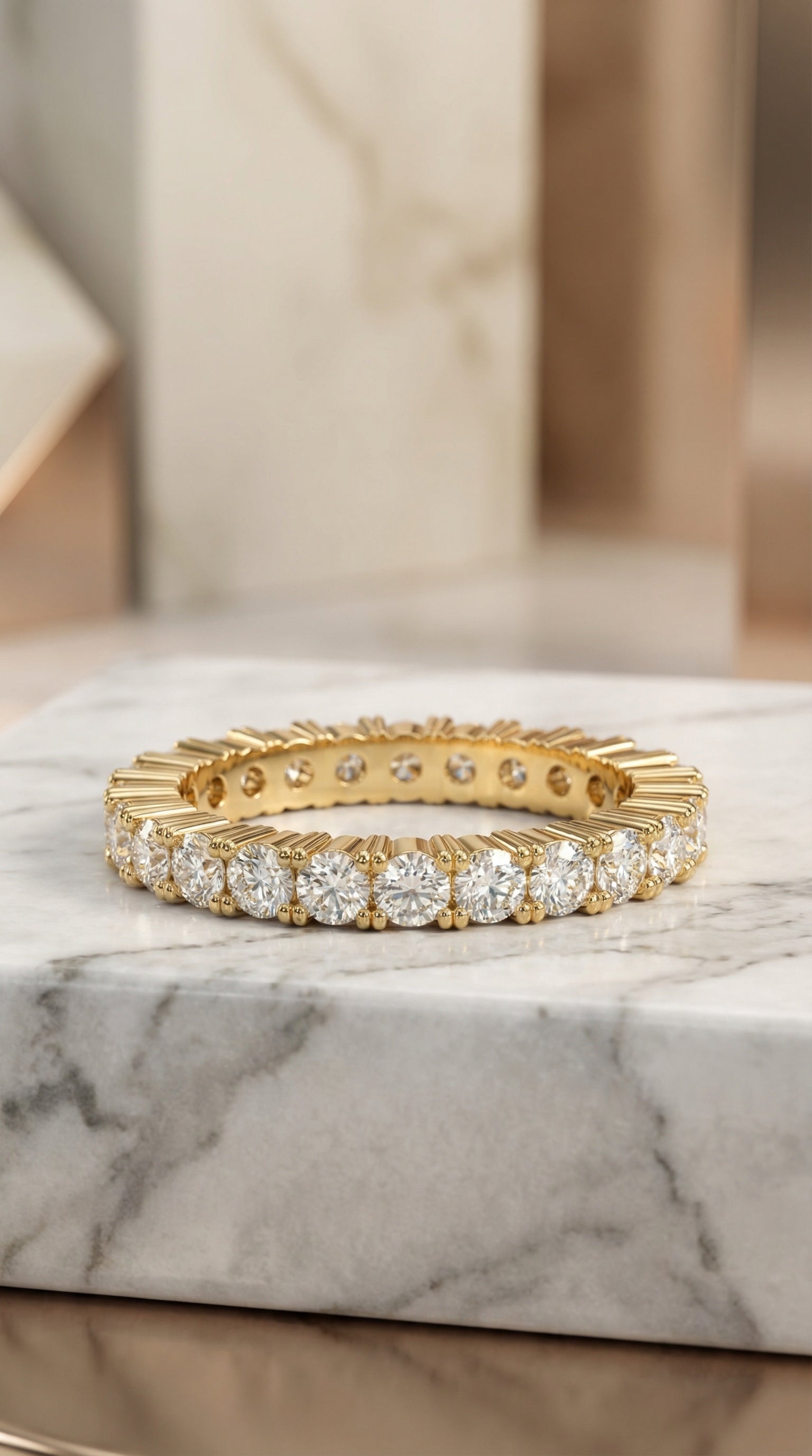 front angle view of round brilliant lab diamond eternity band ring showing continuous diamond row with sculpted fluted gold structure and refined minimal luxury aesthetic