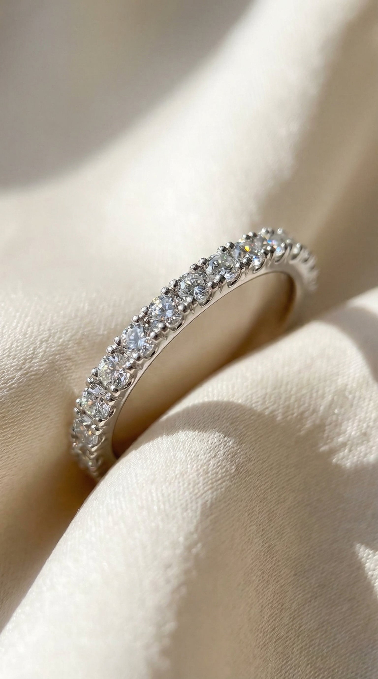 angled macro image of slim round brilliant lab grown diamond band showing shared prong row setting and continuous sparkle across the top of the ring