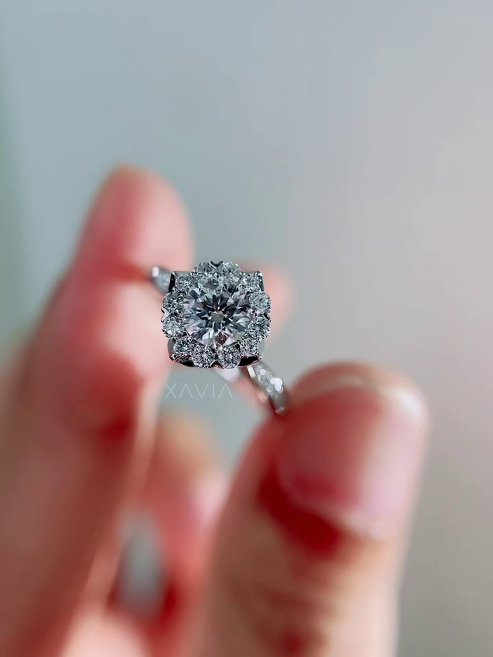 Macro close-up of round brilliant diamond halo engagement ring showing layered sparkle of halo diamonds and pavé band