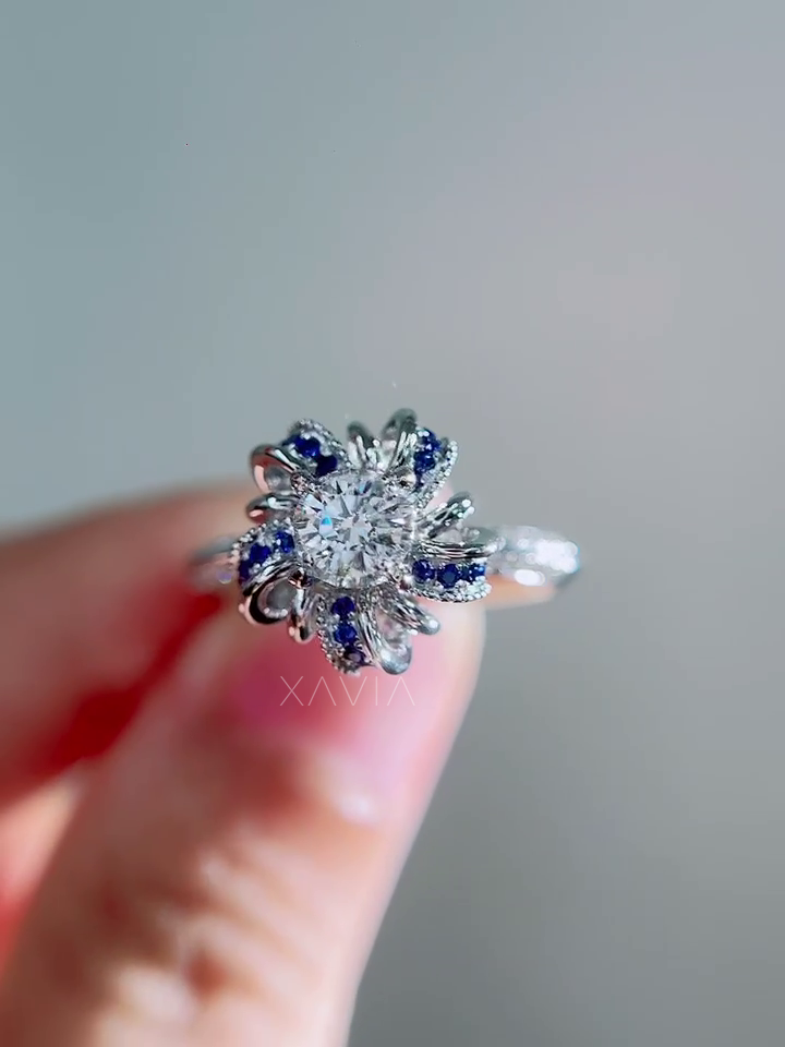 Top view of round brilliant lab grown diamond engagement ring with sculptural sapphire petal halo design and pavé diamond band in white gold