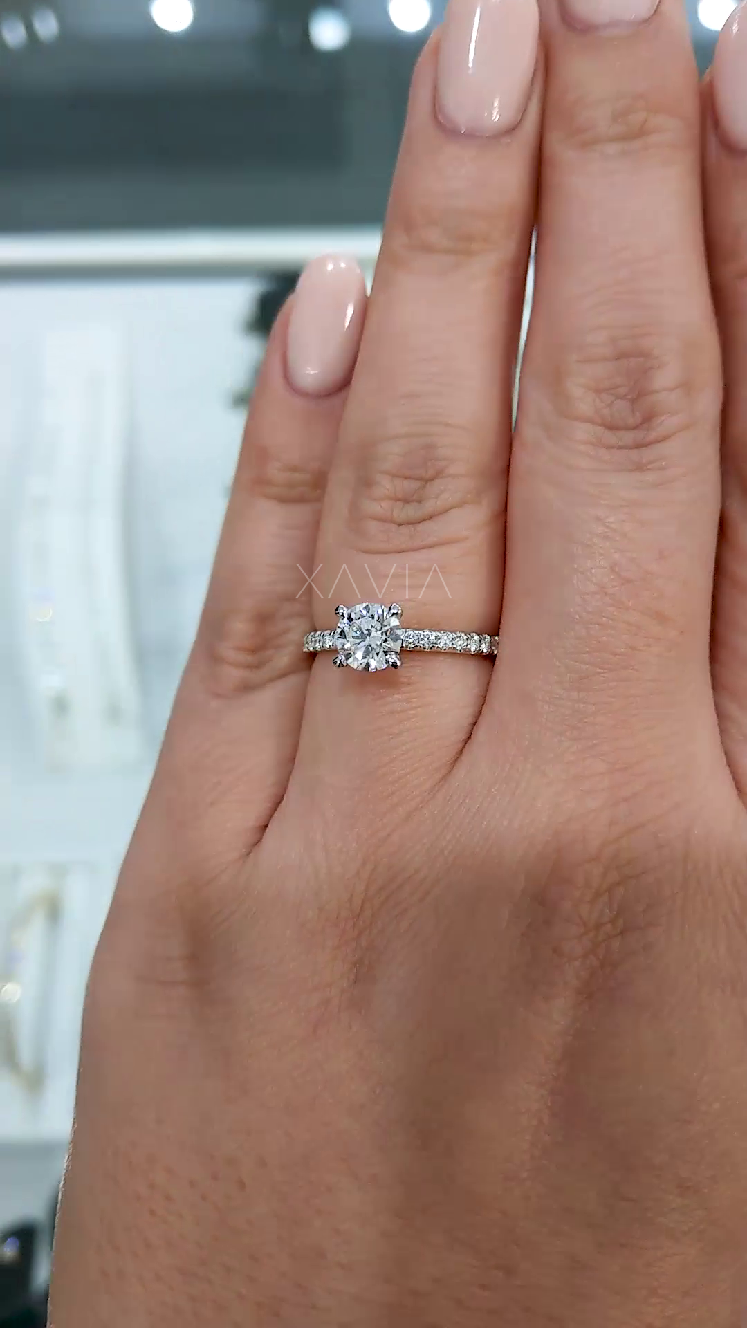 round brilliant lab grown diamond solitaire engagement ring with micro pave band worn on hand, showcasing elegant prong setting and fine band detail