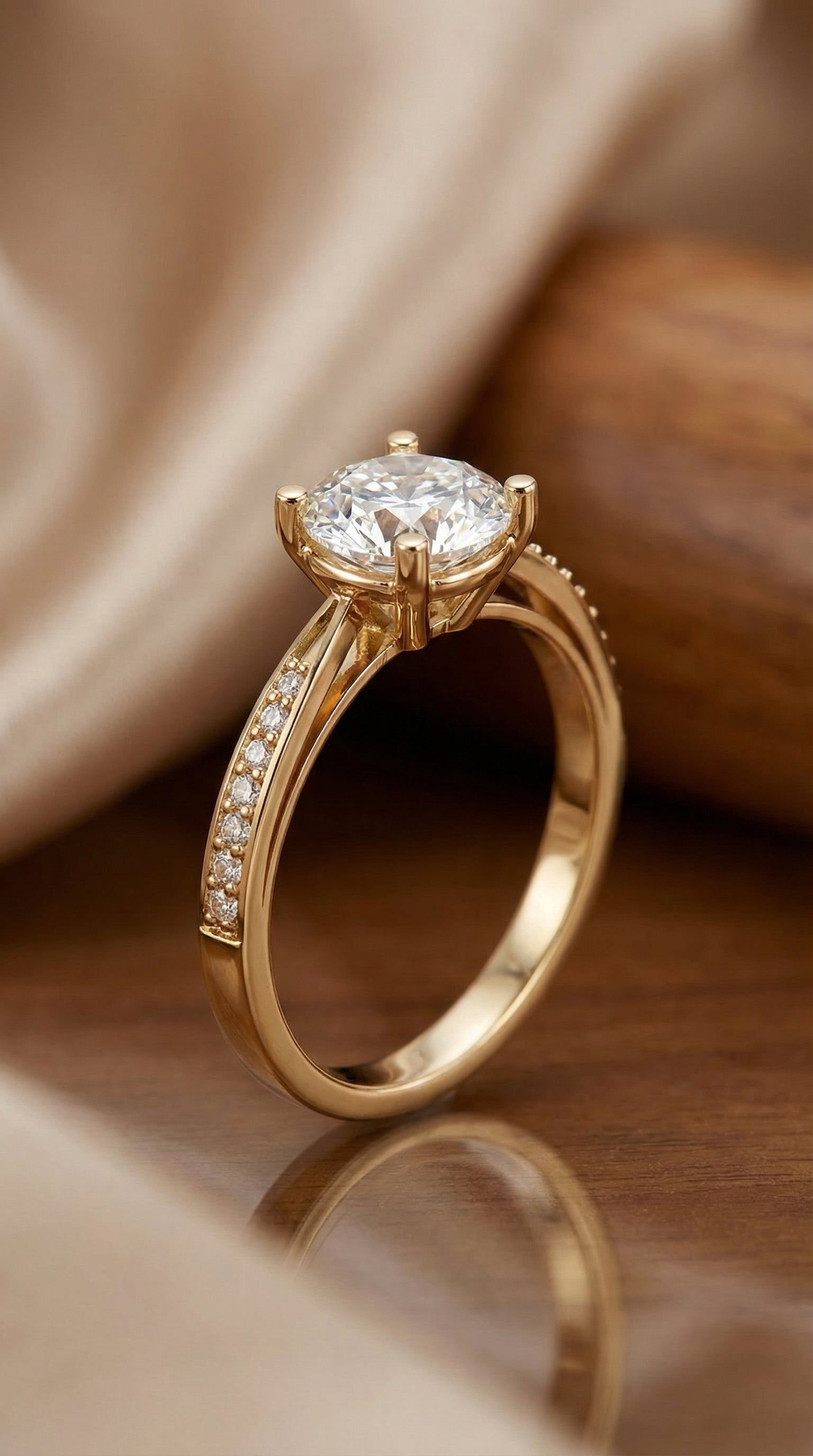luxury round brilliant lab grown diamond solitaire engagement ring with pavé band in yellow gold resting on soft satin background showing brilliant center stone sparkle