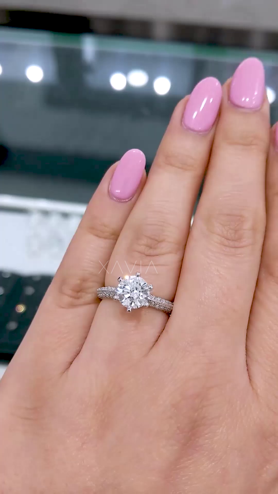 Round brilliant cut solitaire lab diamond engagement ring with pavé split shank and hidden halo, shown on model’s hand