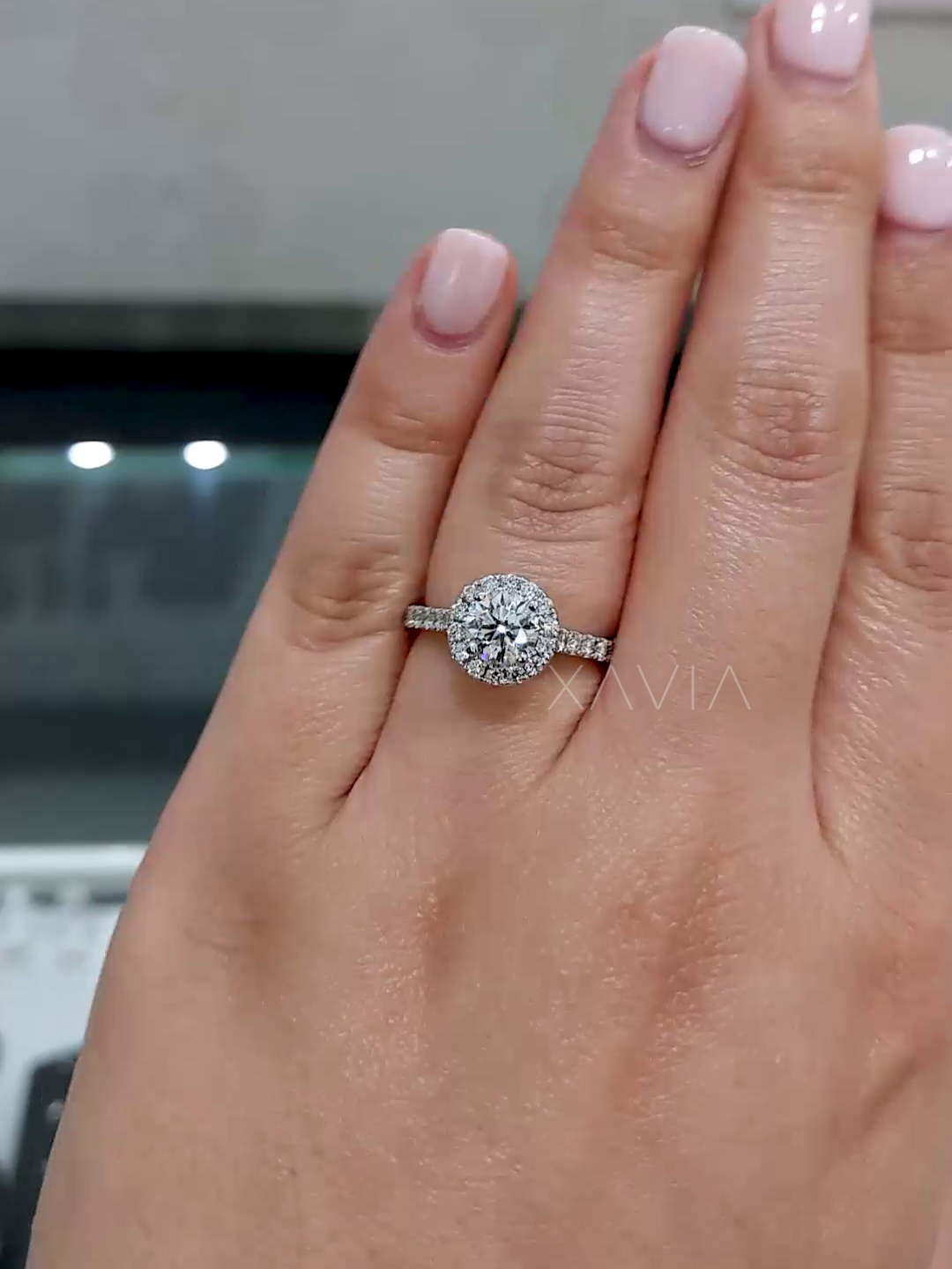 round cut lab diamond halo ring worn on model’s hand