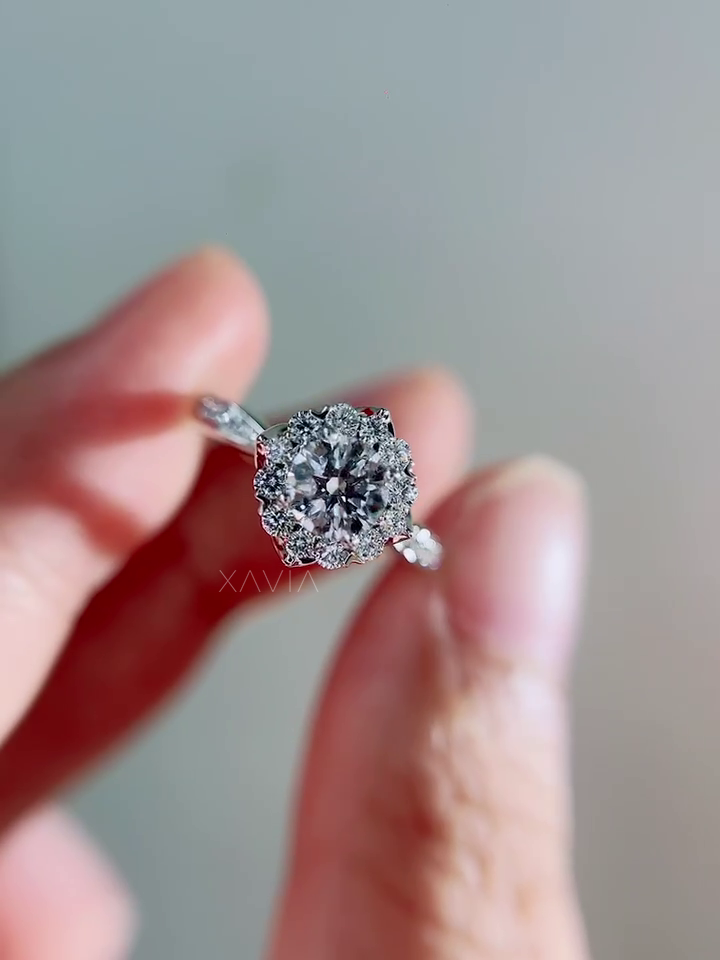 Front angle view of round brilliant halo diamond engagement ring showing clustered halo design and slender pavé diamond shank