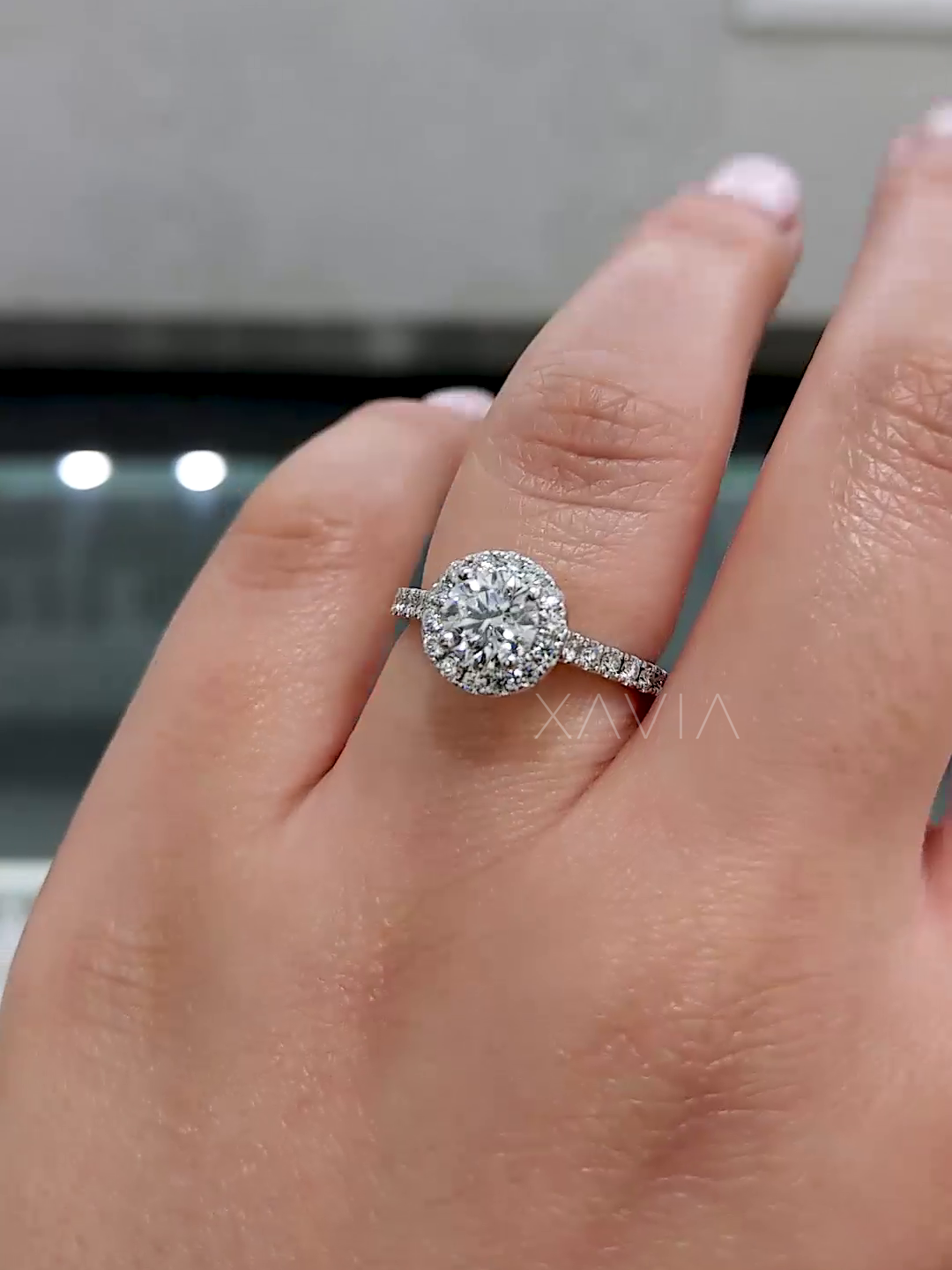 round diamond halo engagement ring on hand from angled view
