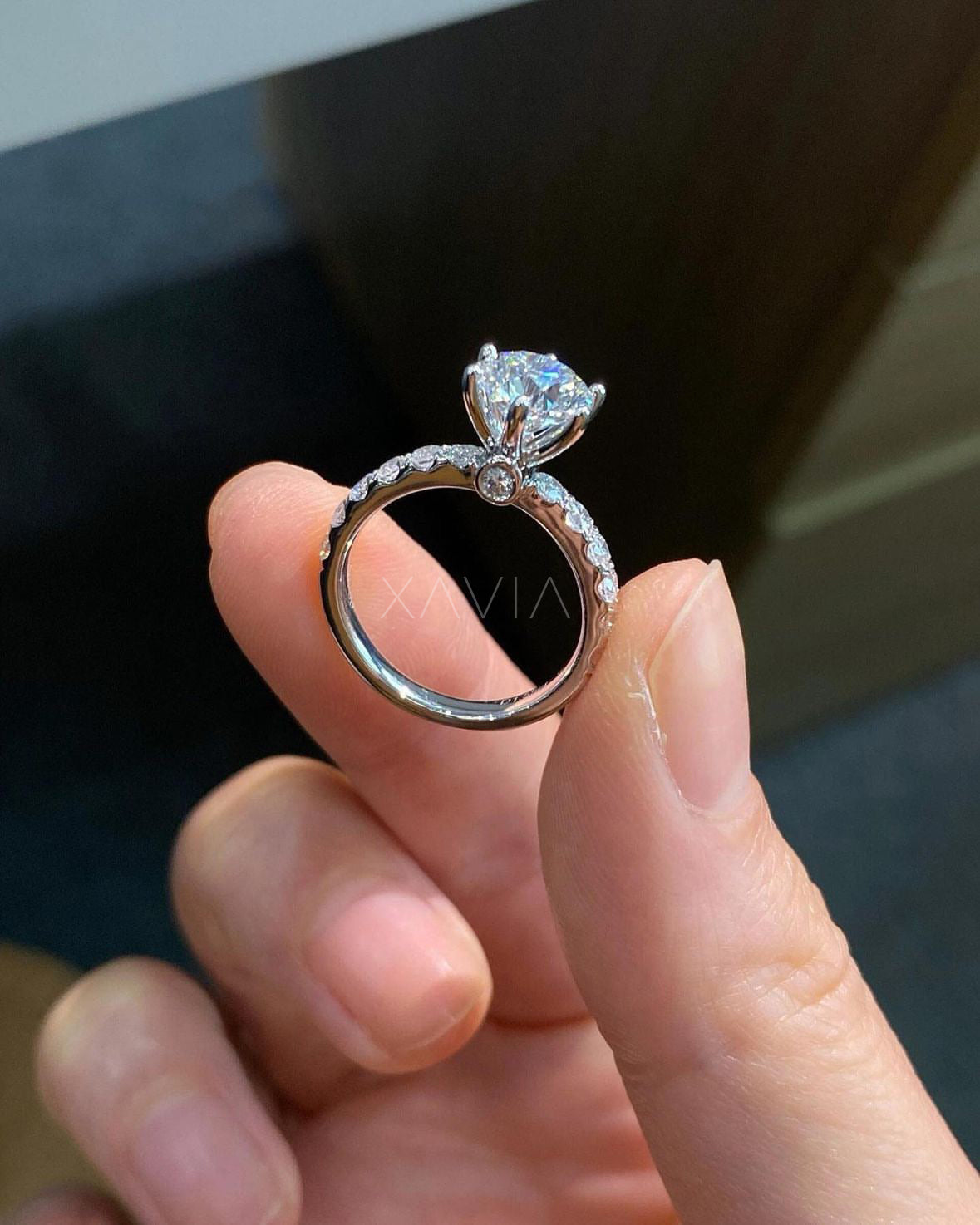 side angle of round brilliant solitaire diamond ring with pavé band