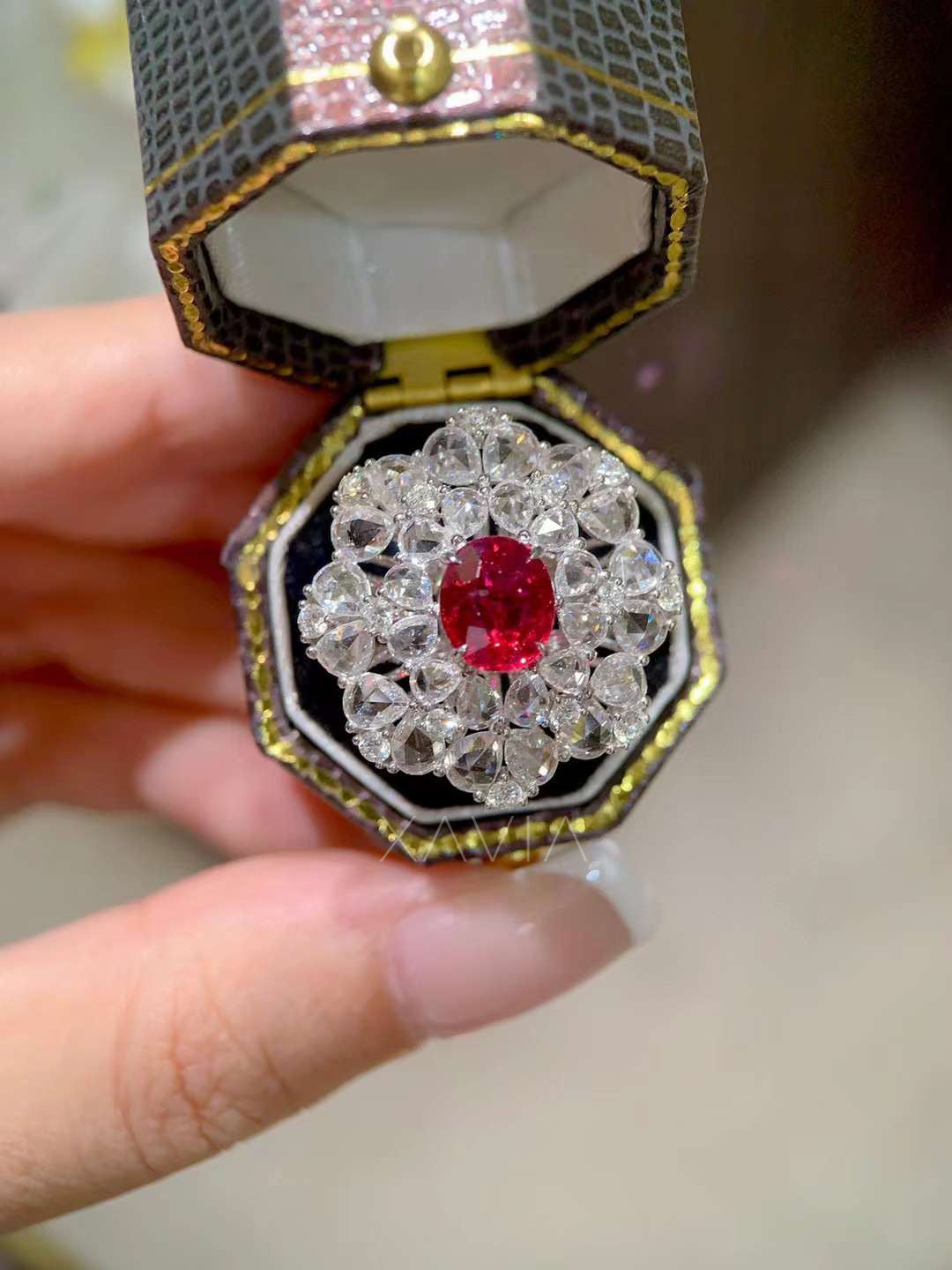 Top view of oval ruby center gemstone ring with round brilliant lab grown diamonds arranged in a floral cluster halo creating intense sparkle