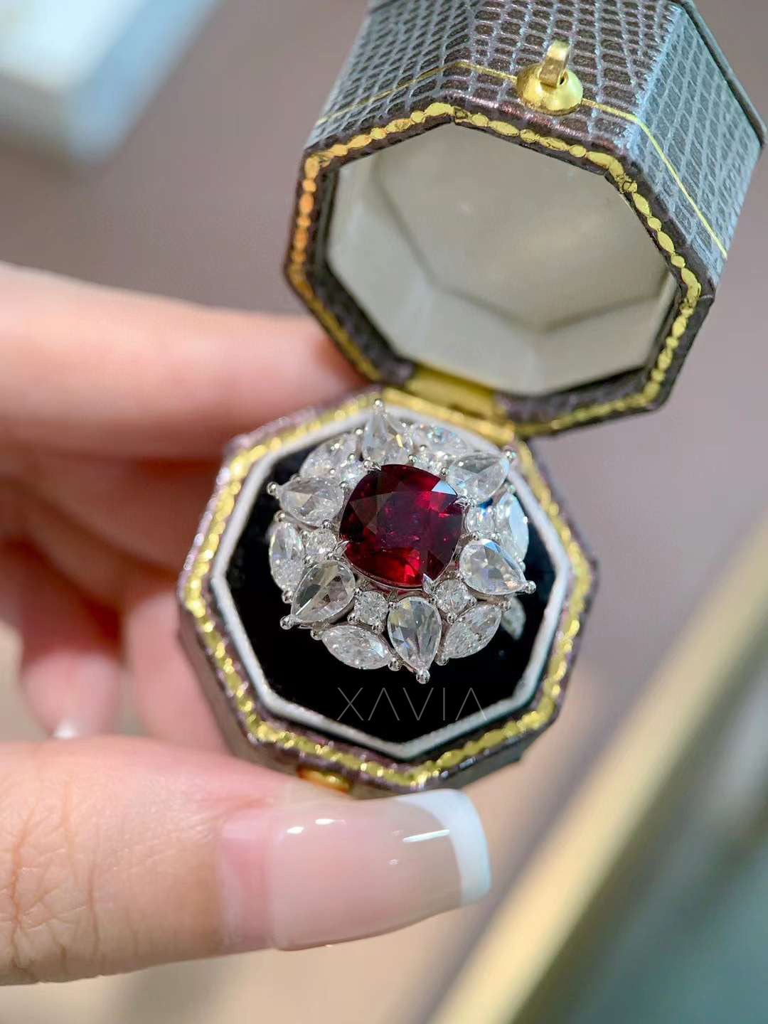 angled side profile of Astrielle ruby ring with cushion ruby center and lab diamond pear and marquise halo in platinum
