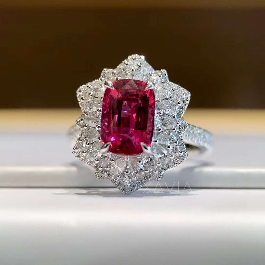 Close-up of cushion ruby engagement ring with diamond petal halo set in platinum band