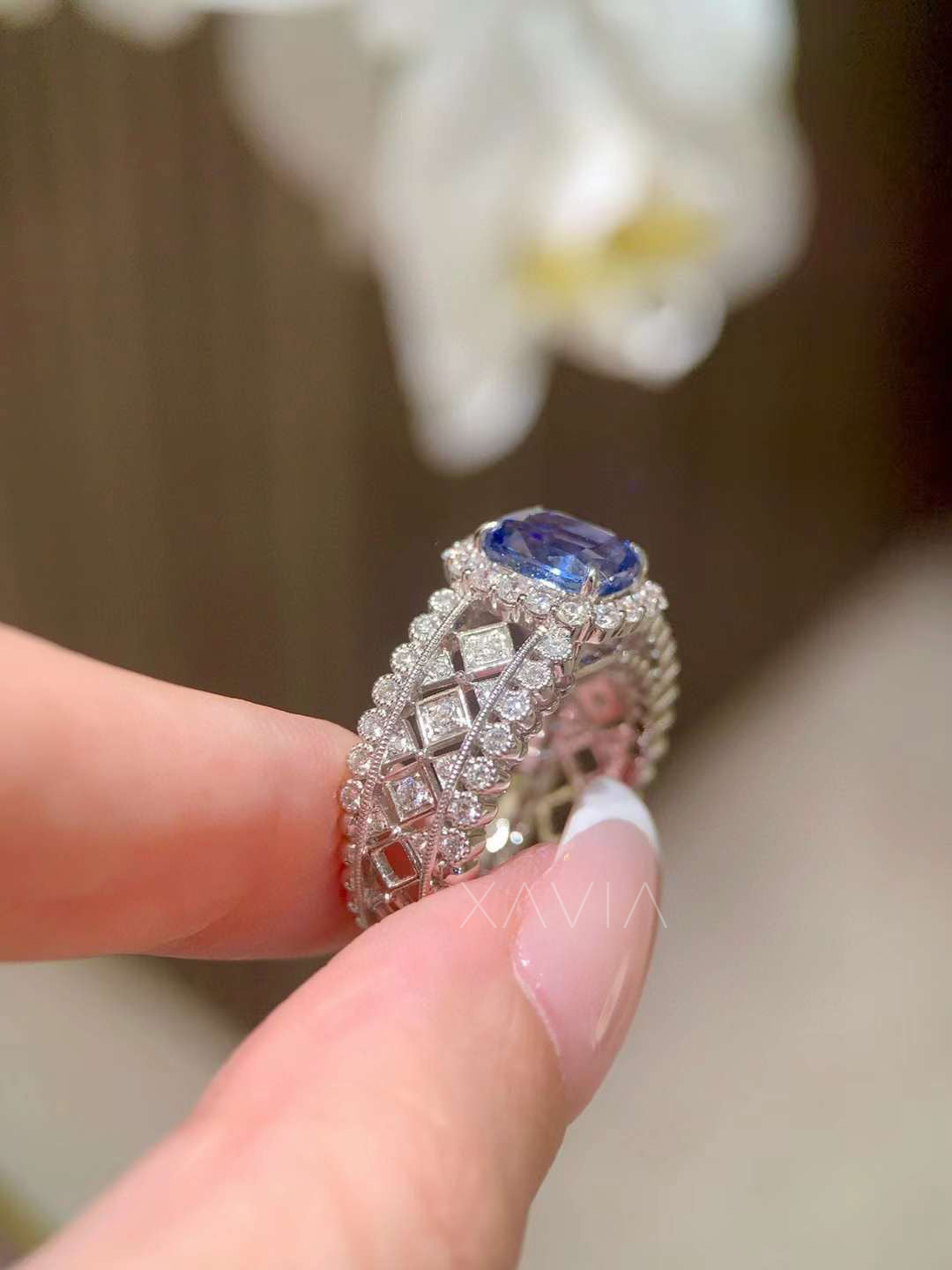side profile showing open lattice diamond gallery beneath sapphire halo with pavé diamond edges and architectural band craftsmanship