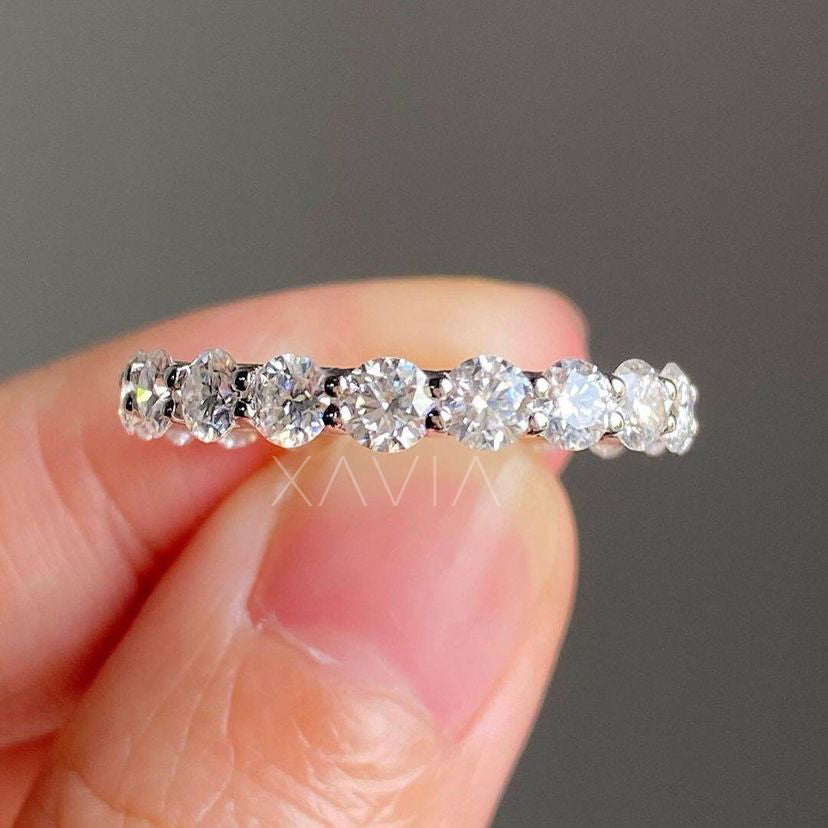 Frontal view of Serenelle ring held between fingers, capturing full circle of DEF diamonds and delicate symmetry.