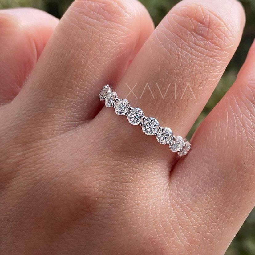 Round lab diamond eternity ring worn on hand, sparkling naturally under soft daylight with shared prong brilliance.