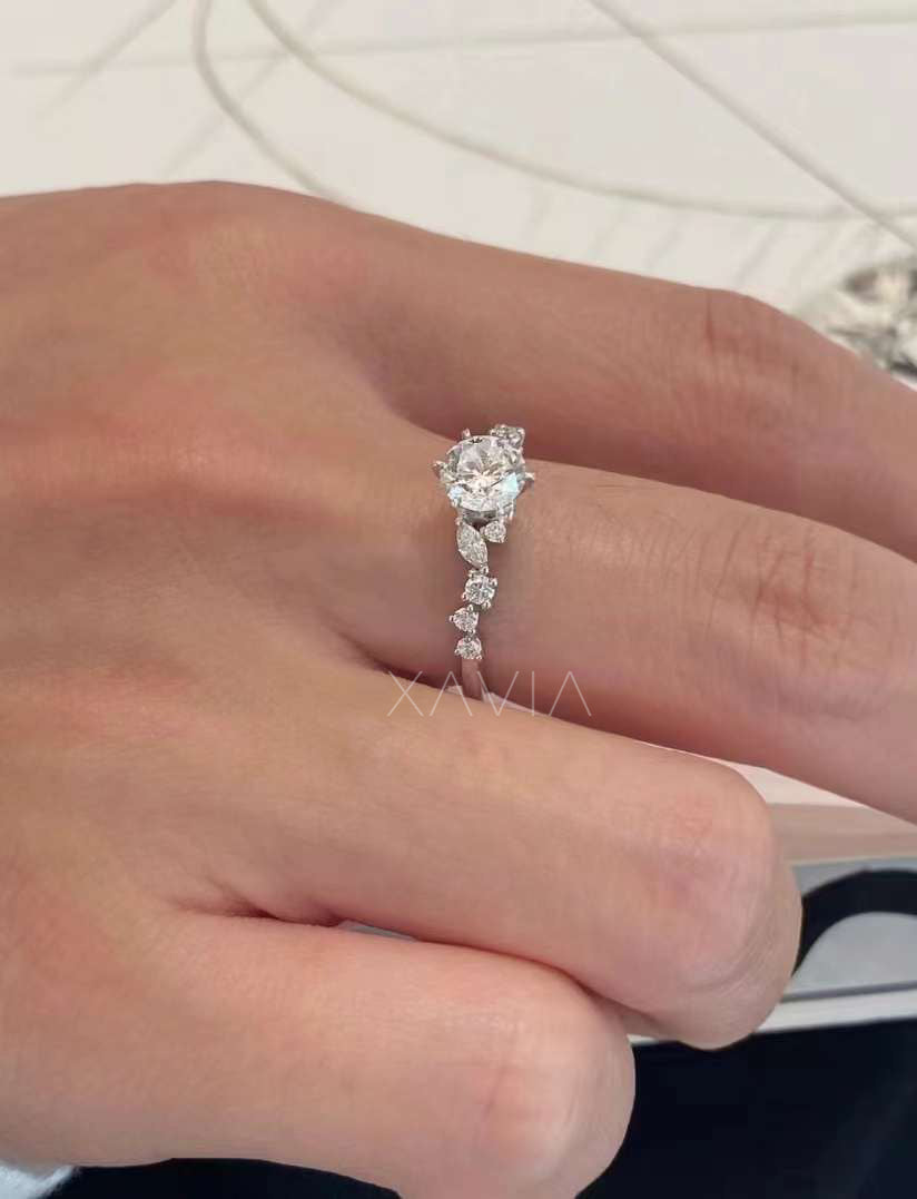 side profile angle of round brilliant lab grown diamond engagement ring showing marquise accent diamonds and sculpted vine style band with delicate diamond detailing