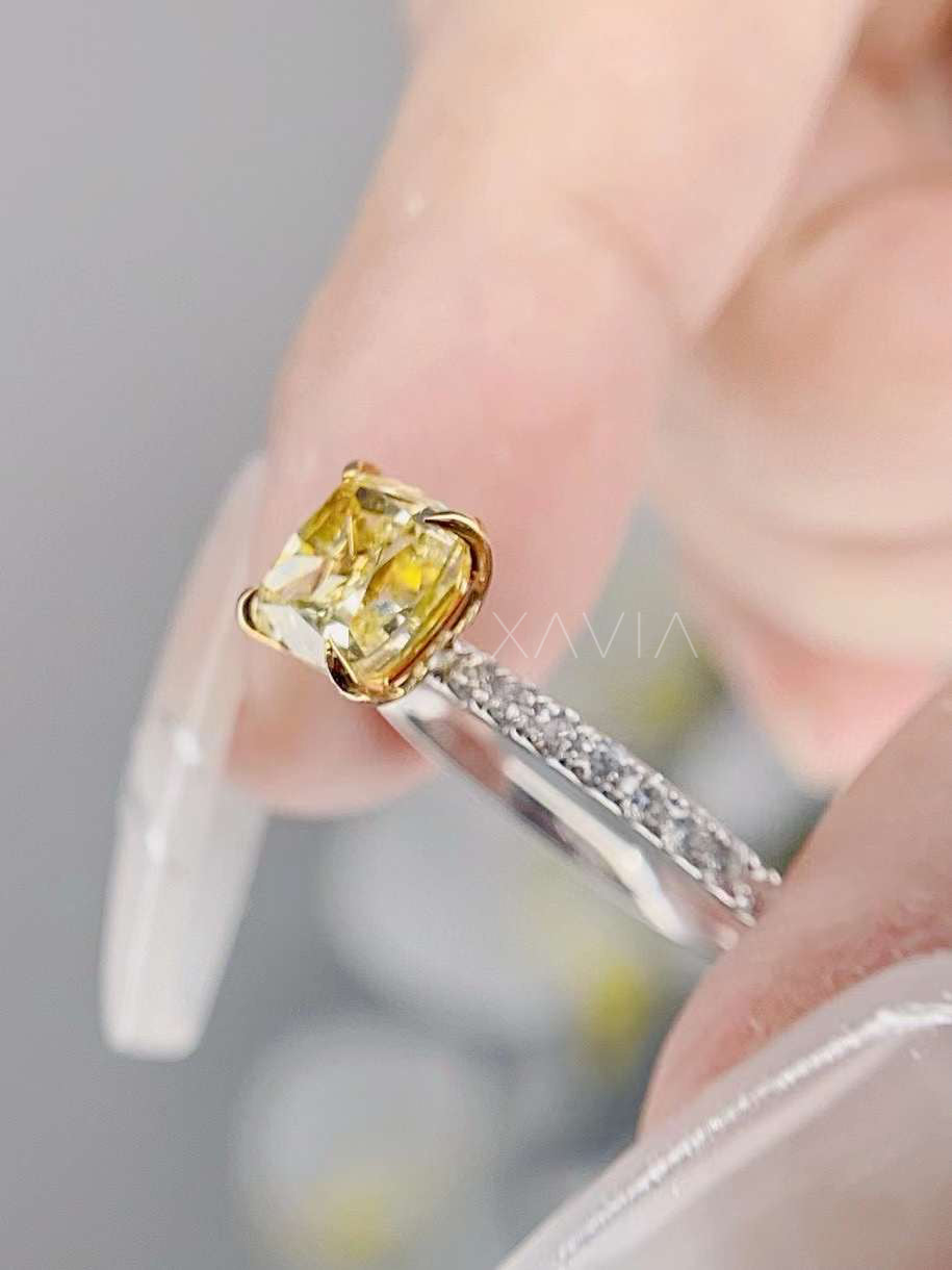angled view of radiant yellow diamond ring in gold prongs