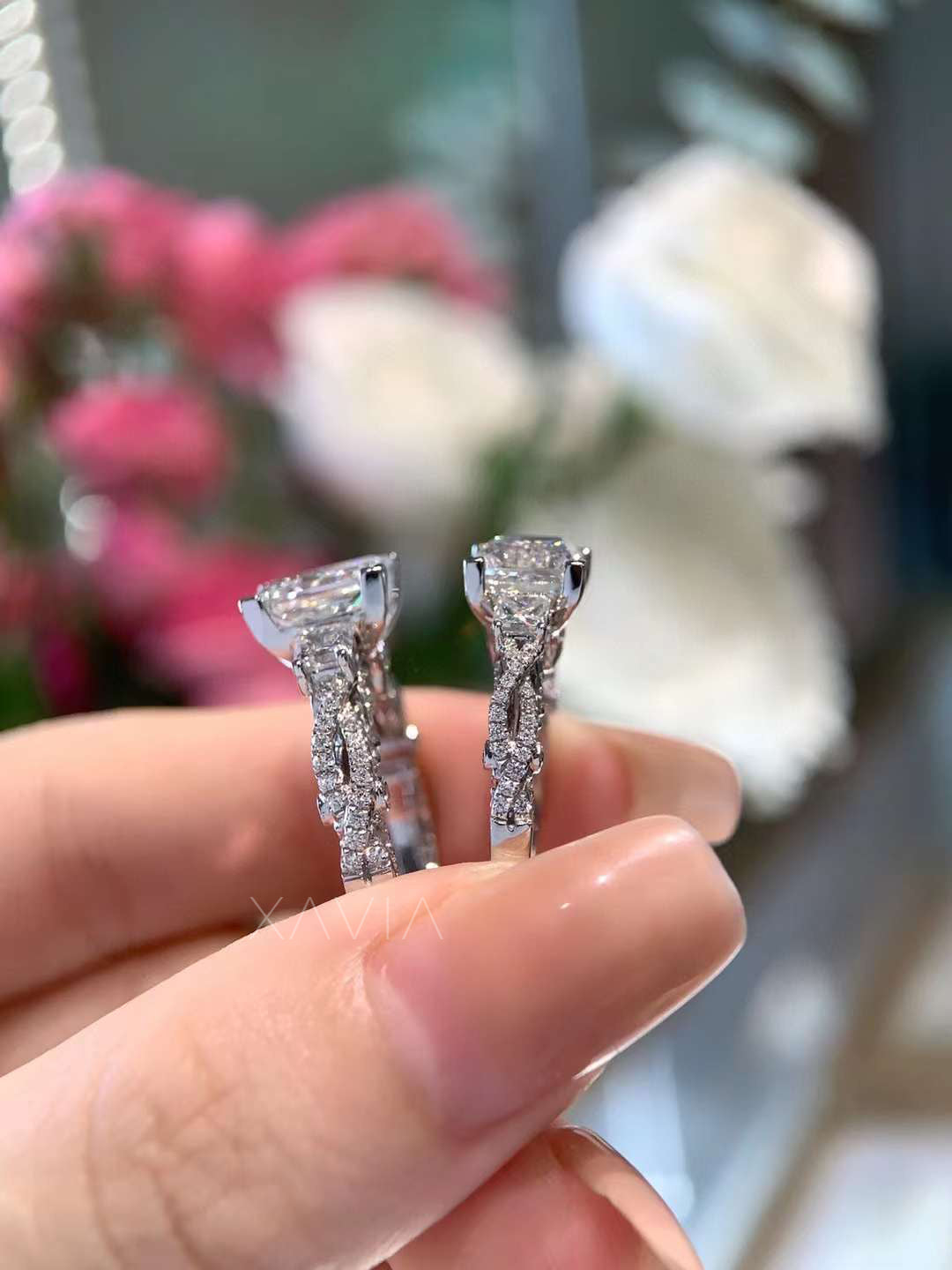 side view showing intricate pavé band and elevated princess cut center diamond in platinum three-stone engagement ring