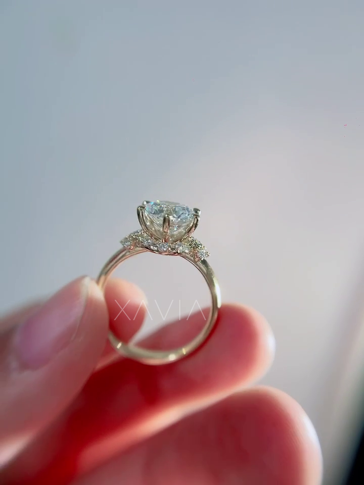 Side profile of round lab grown diamond engagement ring showing elevated cathedral setting with crescent hidden halo beneath center diamond and pavé shoulder accents