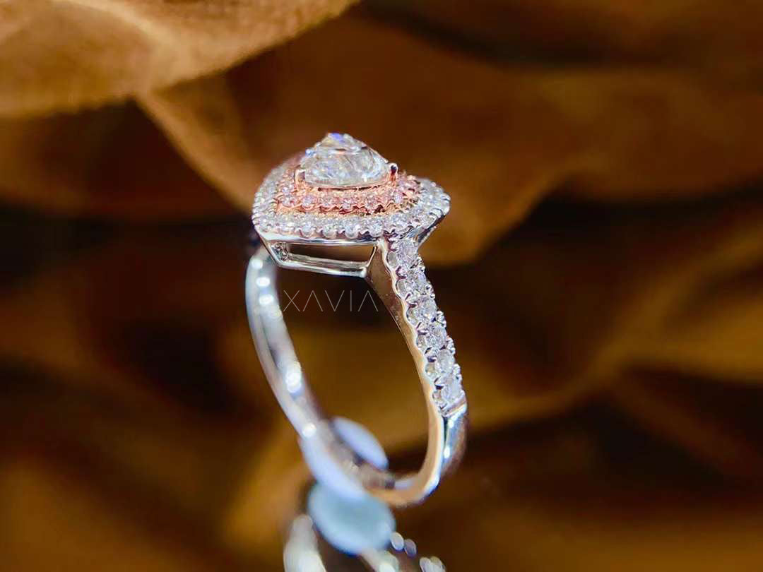 Side profile of heart-shaped diamond ring with double halo pink and white pavé diamonds and pavé band, set in high-polish white gold
