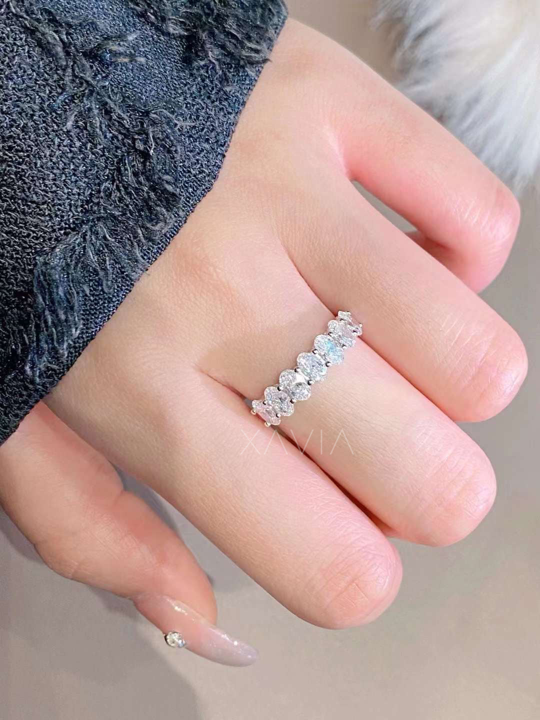 Hand styling with oval lab diamond half eternity band in soft lighting