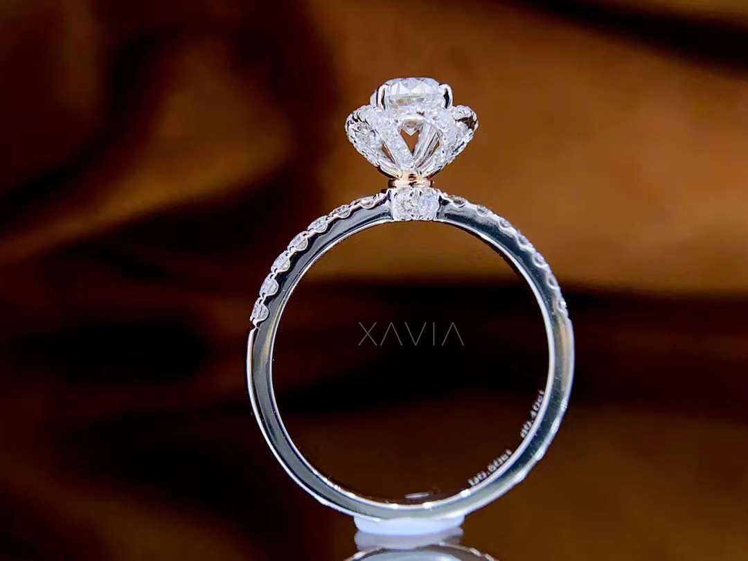 solitaire style round brilliant cut diamond ring enhanced by pavé-set halo petals and slim band