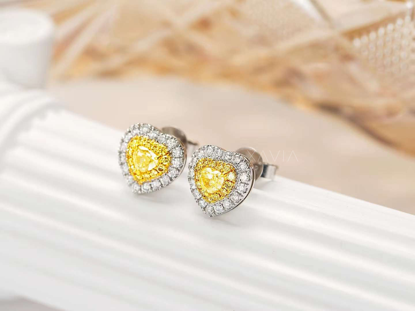Side angle of yellow heart earrings with double halo on textured display
