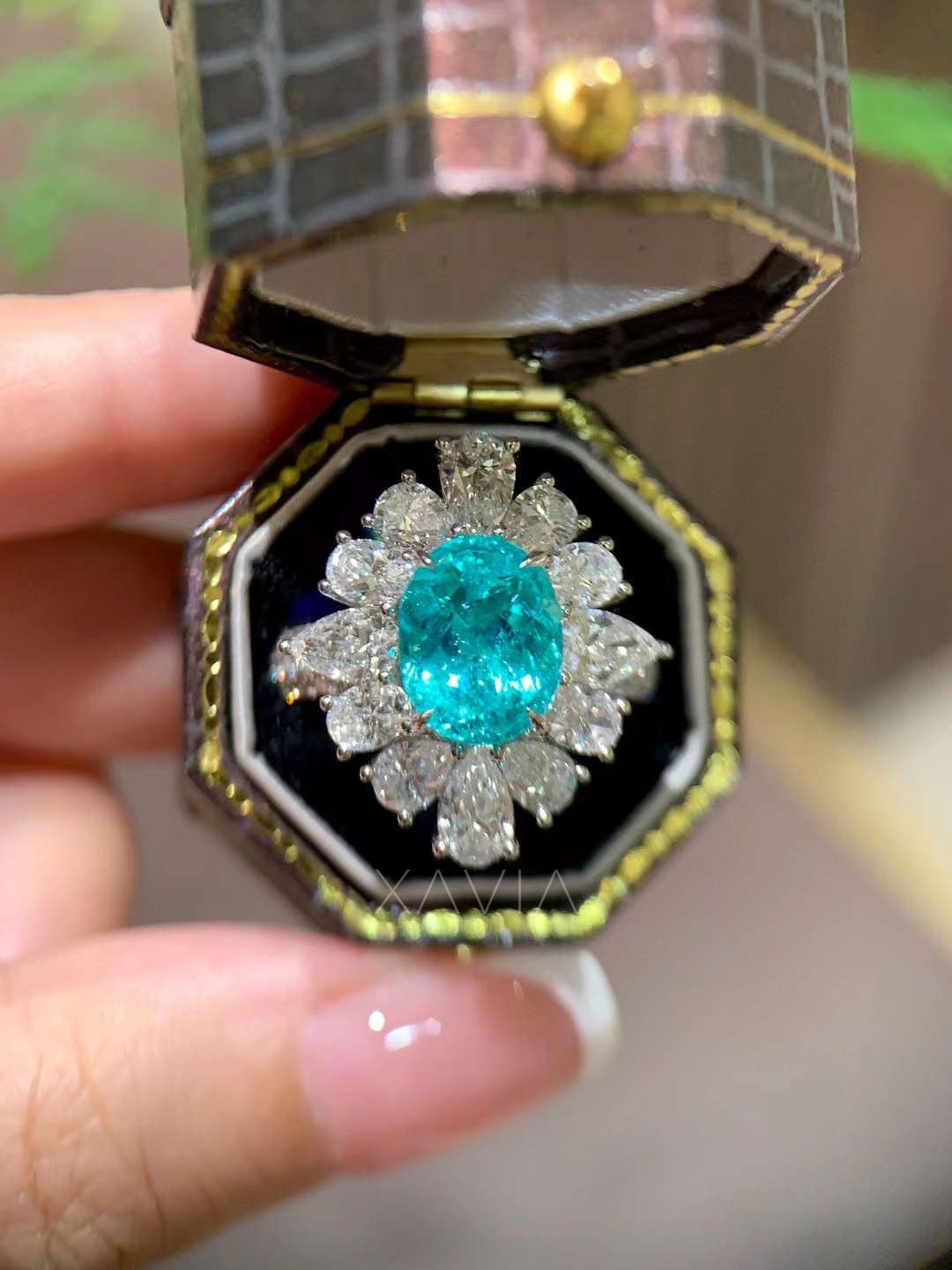 close up of luxury oval teal lab grown diamond cocktail ring inside jewelry box featuring marquise and pear diamond floral halo cluster creating radiant statement design
