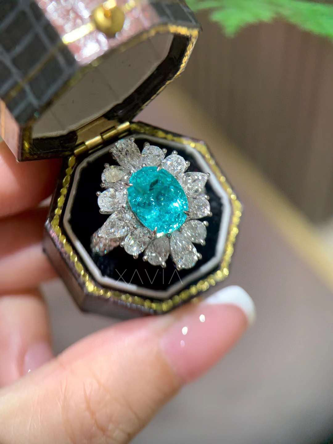 detailed view of teal oval lab grown diamond center surrounded by marquise and pear diamonds forming floral halo cocktail ring with brilliant sparkle