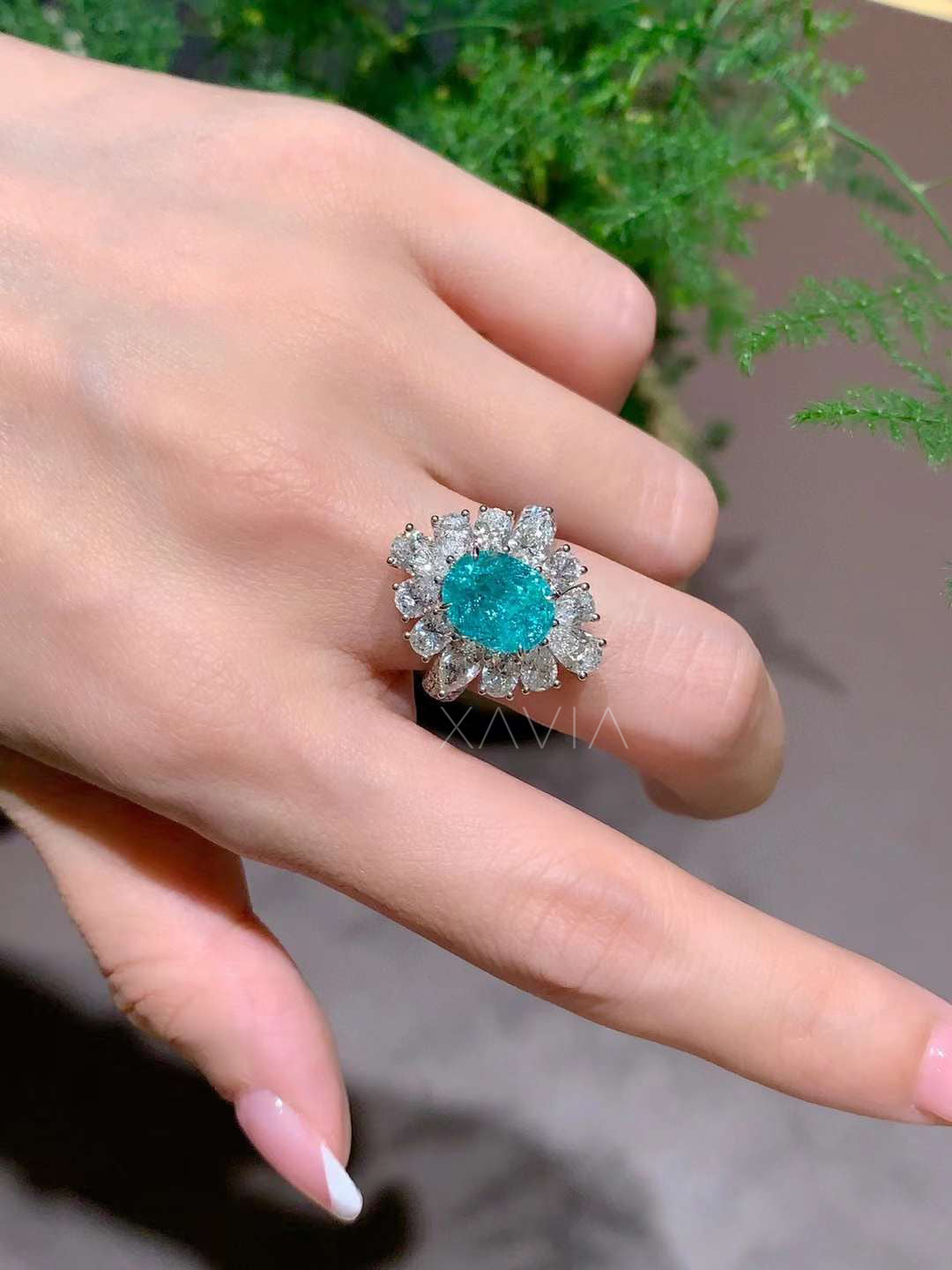 teal oval lab grown diamond floral halo ring worn on hand showing statement cocktail ring with marquise and pear diamond cluster halo design