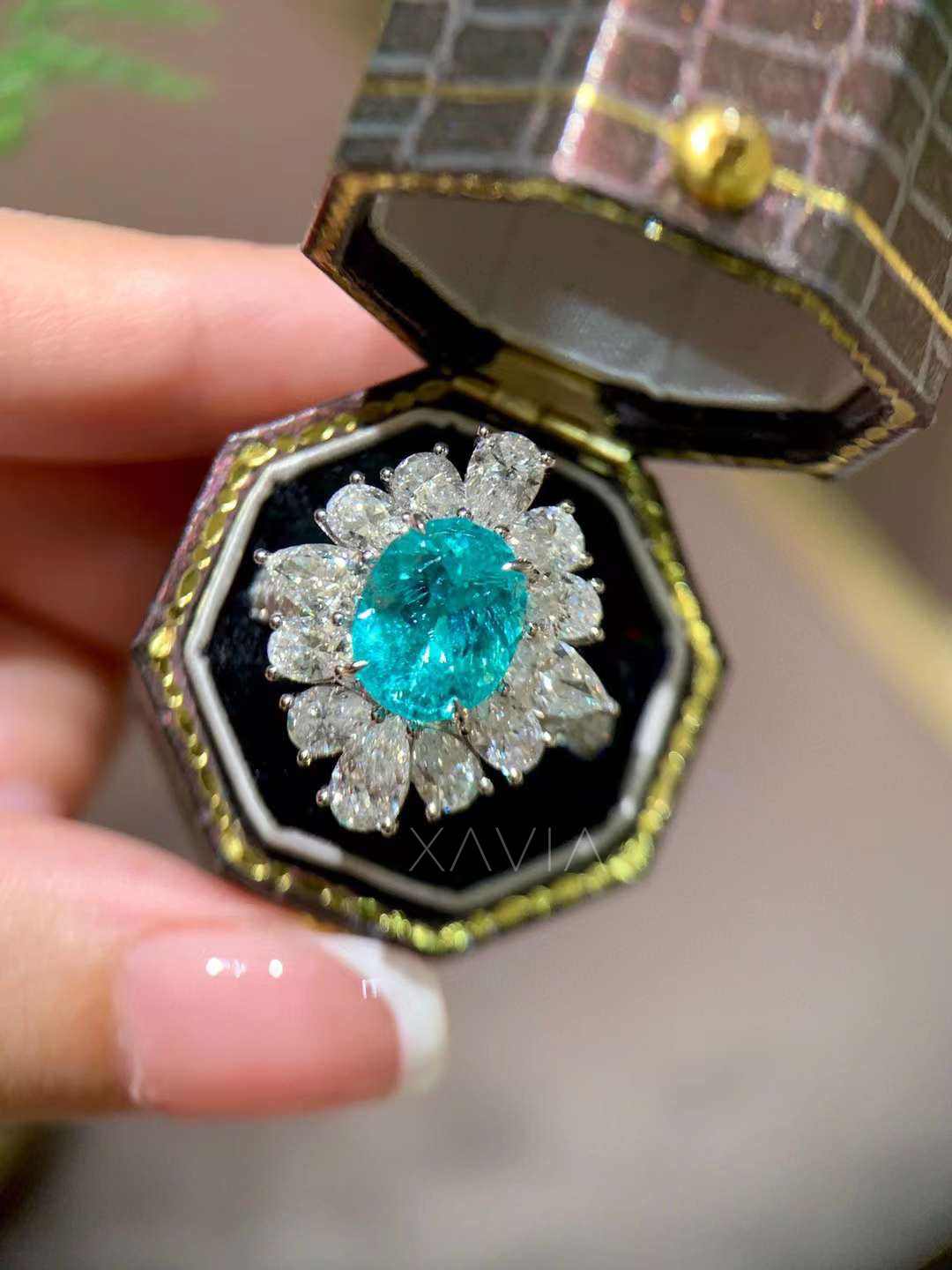 angled view of oval teal lab grown diamond ring with marquise and pear diamond petal halo cluster showcasing bright floral halo cocktail ring design