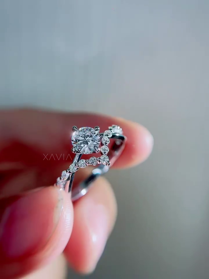 Top angled view of round brilliant lab diamond engagement ring showing symmetrical prong placement, floral pavé accents and flowing vine style band