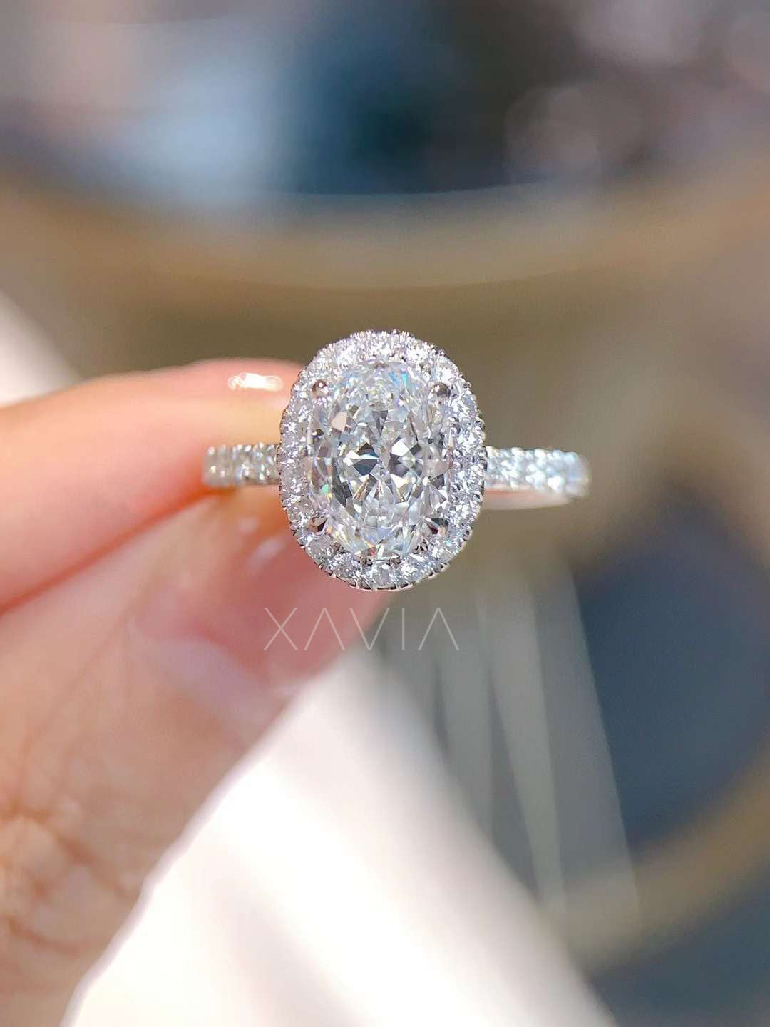 Top view of oval cut halo lab-grown diamond engagement ring with pavé band, showcasing symmetry and fire of center stone