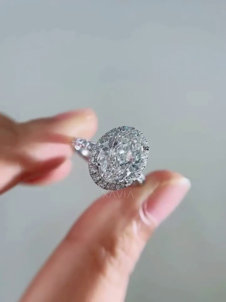 top view of oval cut lab grown diamond surrounded by pavé halo diamonds forming classic halo engagement ring design with high brilliance