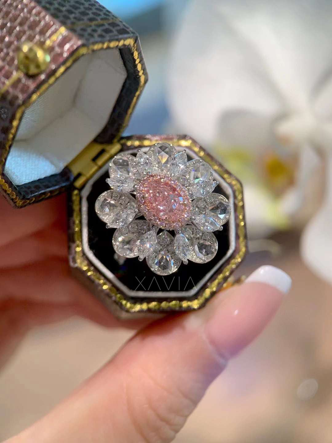 top view of pink center diamond surrounded by double halo in marquise and pear shapes