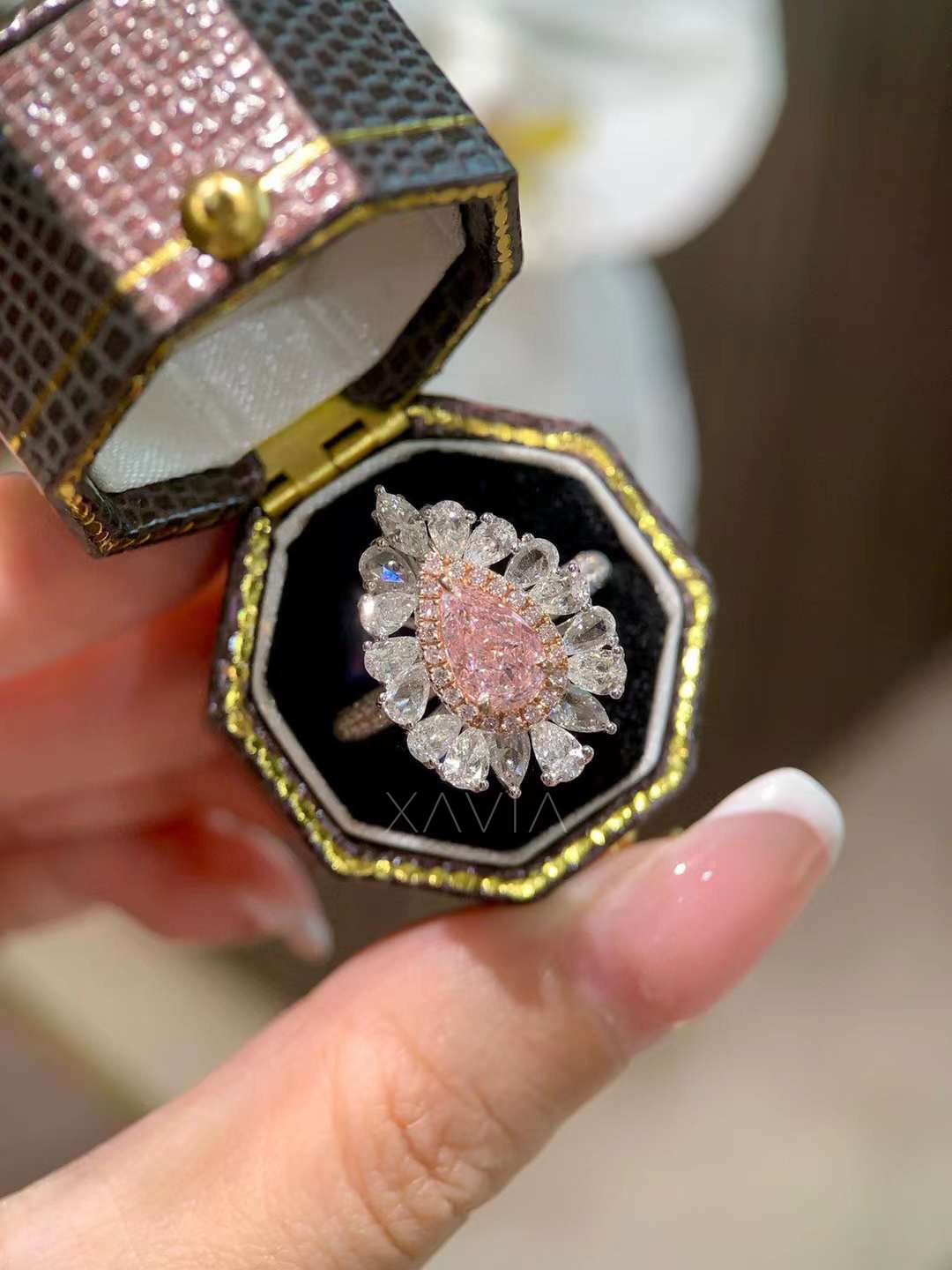 top angle of pink pear diamond halo ring featuring marquise and pear diamond floral cluster setting