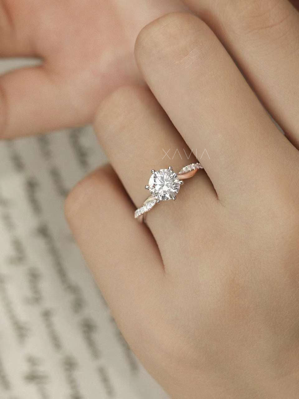Top angle of solitaire engagement ring with round brilliant diamond center stone and pavé twist band